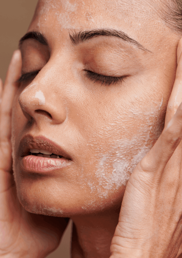 Mujer aplicando productos en su rostro durante su rutina facial para piel grasa y mixta