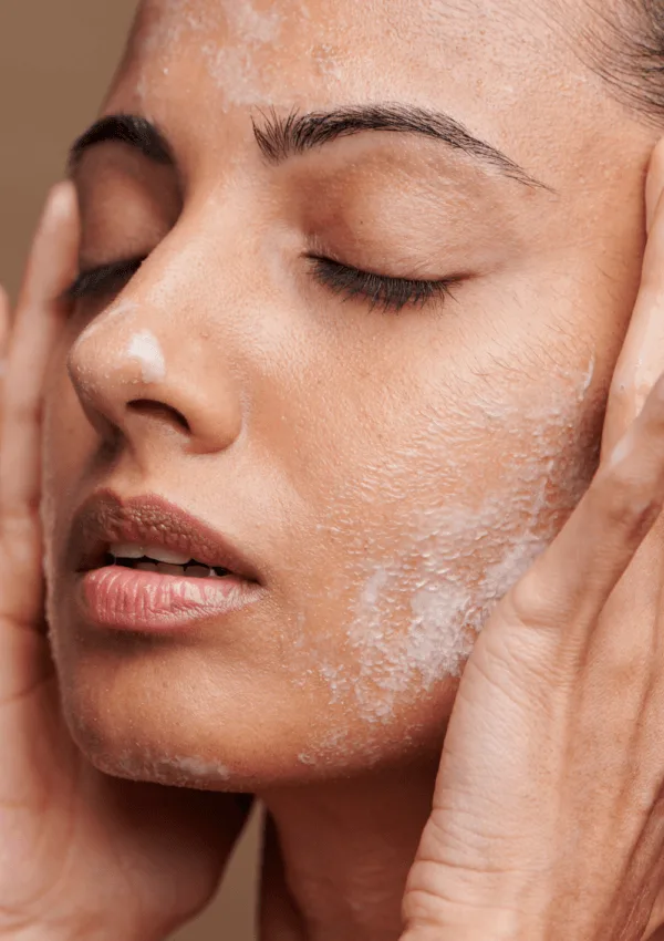 Mujer aplicando productos en su rostro durante su rutina facial para piel grasa y mixta