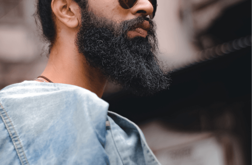 Cuidado de la barba para piel sensible: hombre con barba espesa y peinado moderno.
