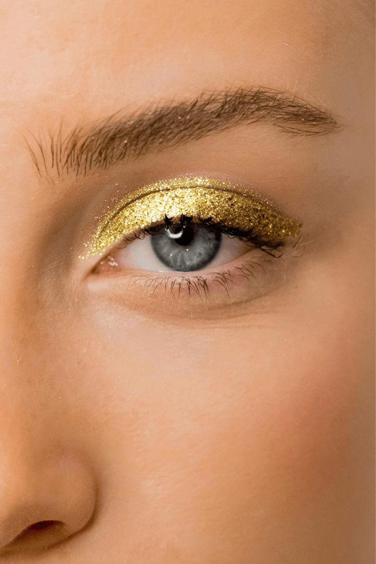 Sombras de ojos liquidos. Ojo maquillado con sombra líquida dorada y efecto glitter.