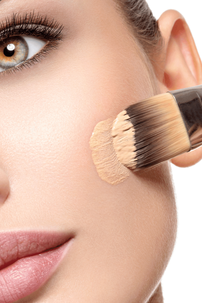Aplicación de base de maquillaje líquida con brocha sobre la piel del rostro